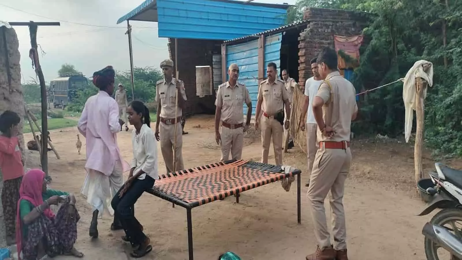 ग्रामीण इलाके में खाकी वर्दी पहने पुलिसकर्मी स्थानीय नागरिकों से बातचीत करते हुए नजर आ रहे हैं। ग्रामीण इलाके में खाकी वर्दी पहने पुलिसकर्मी स्थानीय नागरिकों से बातचीत करते हुए नजर आ रहे हैं।