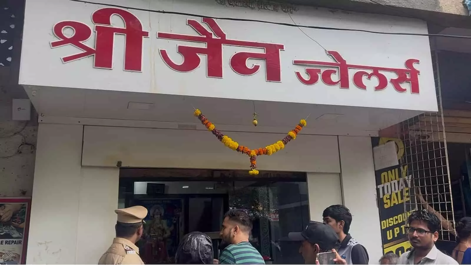 श्री जैन ज्वैलर्स शॉप के बाहर खड़े लोग और पुलिसकर्मी मोरेगांव नालासोपारा पूर्व में। श्री जैन ज्वैलर्स शॉप के बाहर खड़े लोग और पुलिसकर्मी मोरेगांव नालासोपारा पूर्व में।