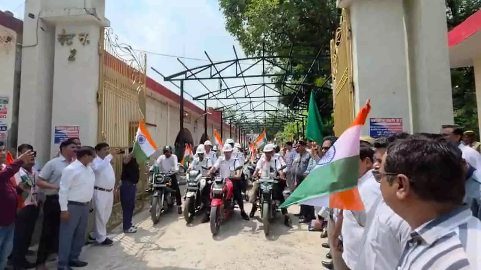तिरंगे के साथ मोटरसाइकिल सवार और लोग एक परिसर के बाहर यात्रा में दिखाई दे रहे हैं तिरंगे के साथ मोटरसाइकिल सवार और लोग एक परिसर के बाहर यात्रा में दिखाई दे रहे हैं
