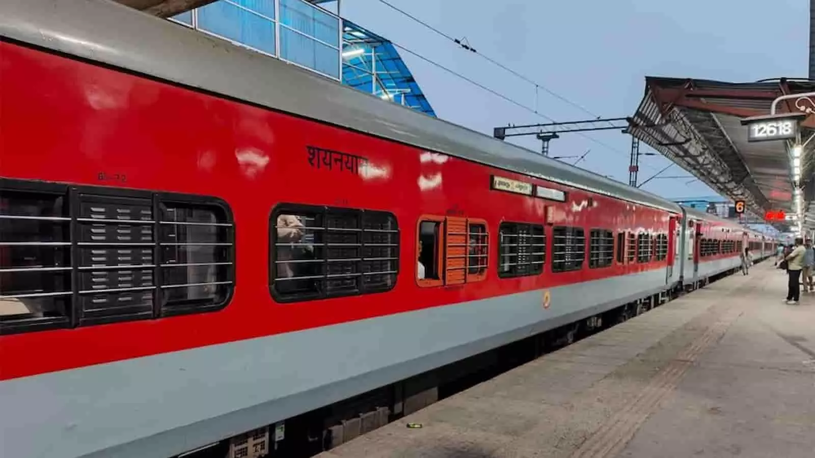 रेलवे स्टेशन के प्लेटफॉर्म पर खड़ी लाल और ग्रे रंग की ट्रेन। रेलवे स्टेशन के प्लेटफॉर्म पर खड़ी लाल और ग्रे रंग की ट्रेन।