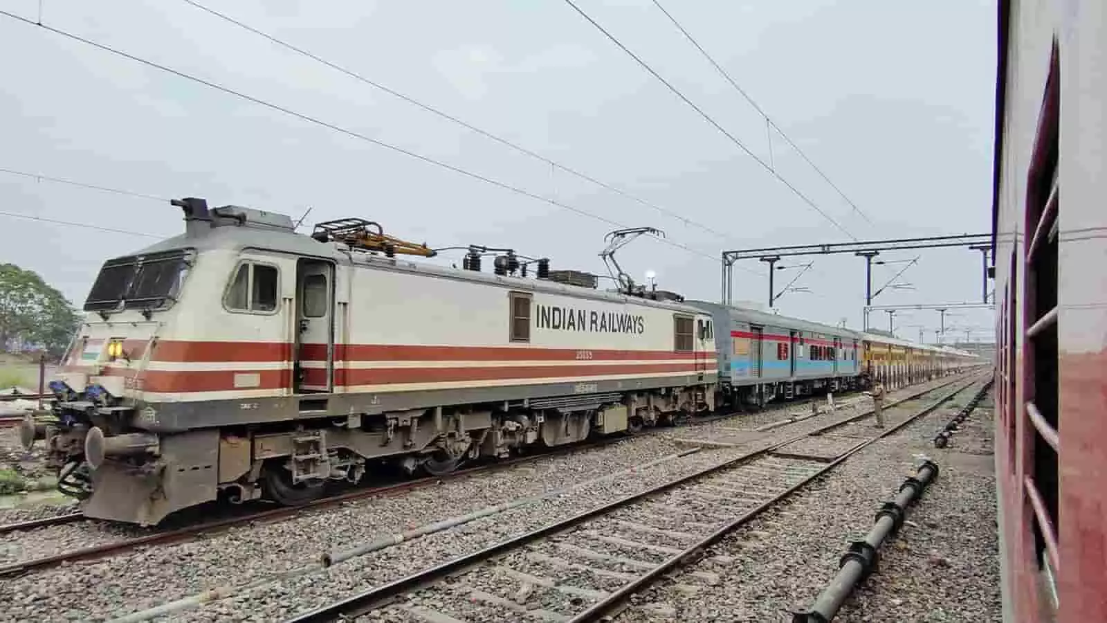 रेलवे ट्रैक पर खड़ी भारतीय रेलवे की ट्रेन दिखाई दे रही है। रेलवे ट्रैक पर खड़ी भारतीय रेलवे की ट्रेन दिखाई दे रही है।