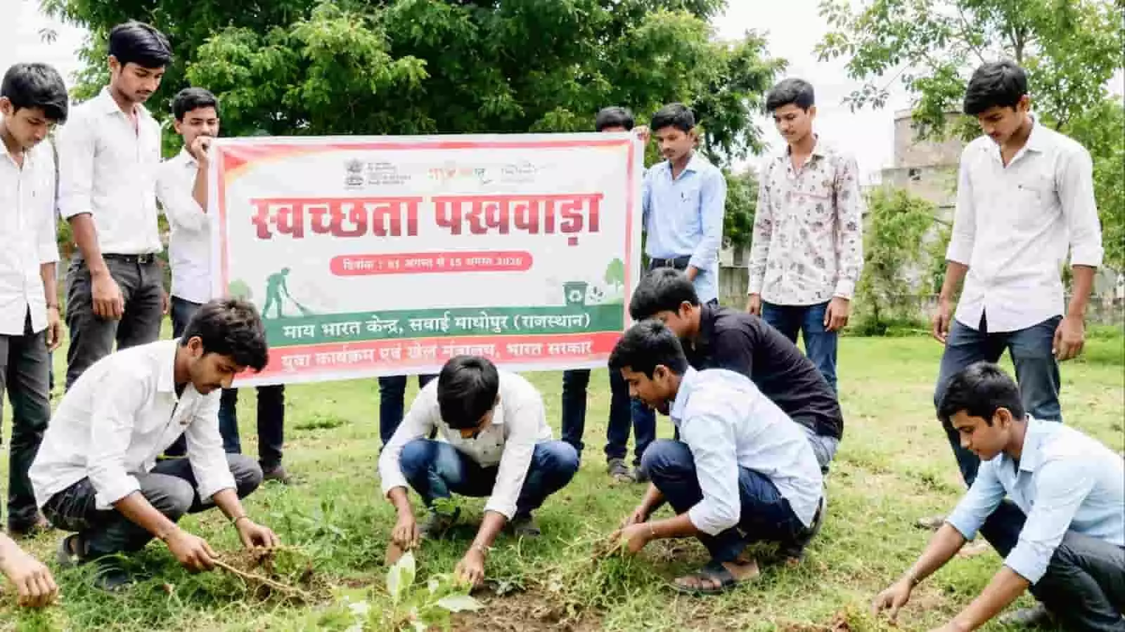 तस्वीर में युवा स्वयंसेवक स्वच्छता पखवाड़ा का बैनर पकड़े हुए और खुले मैदान में श्रमदान करते दिख रहे हैं। तस्वीर में युवा स्वयंसेवक स्वच्छता पखवाड़ा का बैनर पकड़े हुए और खुले मैदान में श्रमदान करते दिख रहे हैं।