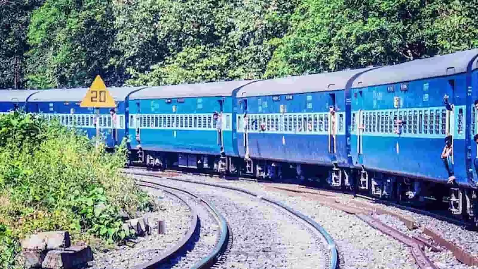 तस्वीर में पटरियों पर चलती हुई नीले रंग की एक्सप्रेस ट्रेन दिख रही है। तस्वीर में पटरियों पर चलती हुई नीले रंग की एक्सप्रेस ट्रेन दिख रही है।
