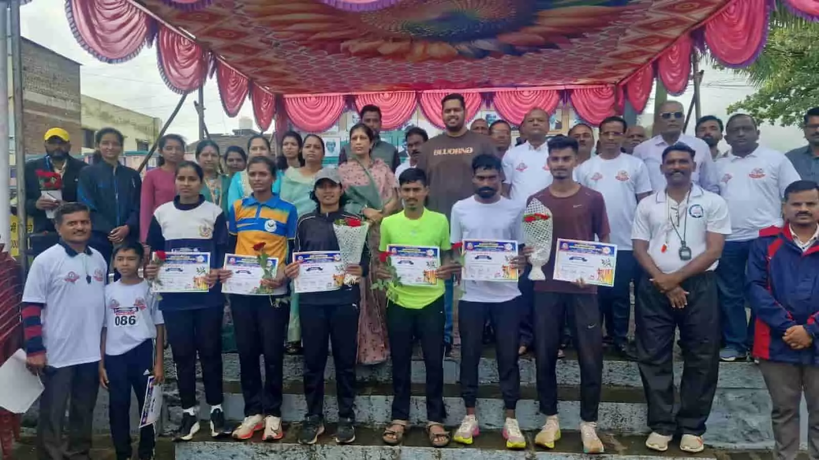 मुरगूड में मैराथन प्रतियोगिता के विजेता धावक और अतिथि मंच पर खड़े हैं। मुरगूड में मैराथन प्रतियोगिता के विजेता धावक और अतिथि मंच पर खड़े हैं।