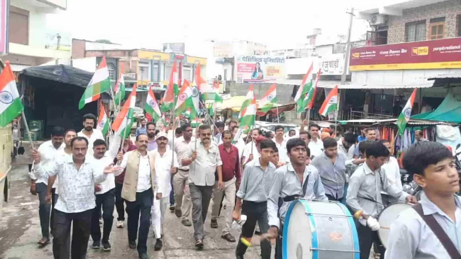 तस्वीर में झाड़ोल में हाथों में तिरंगे झंडे लेकर सड़क पर चलते हुए स्कूली बच्चे और लोग दिख रहे हैं। तस्वीर में झाड़ोल में हाथों में तिरंगे झंडे लेकर सड़क पर चलते हुए स्कूली बच्चे और लोग दिख रहे हैं।