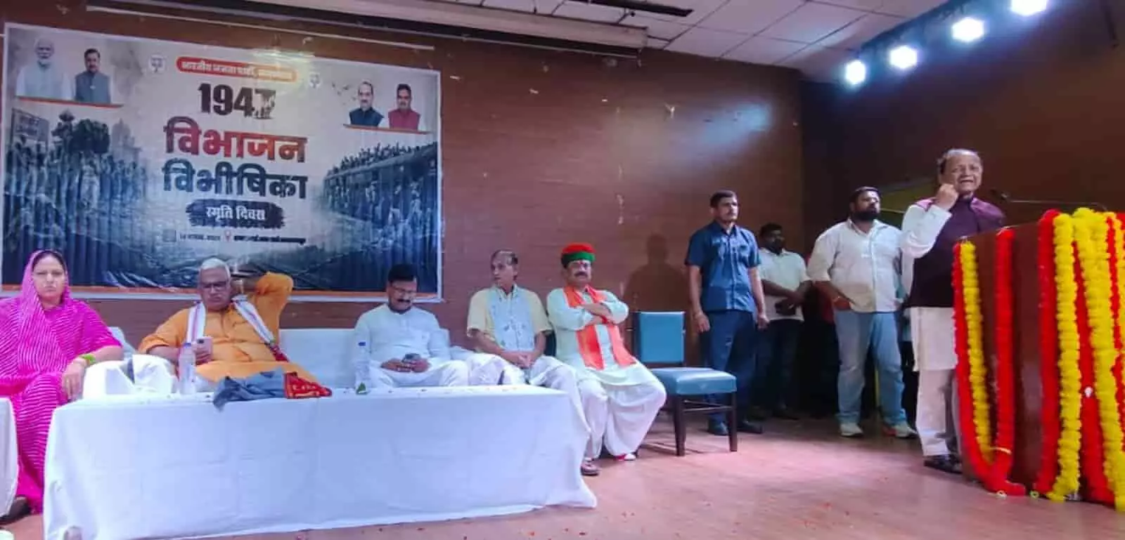 तस्वीर में भरतपुर के कार्यक्रम में मंच पर बैठे अतिथि और भाषण देते अरुण सिंह दिख रहे हैं। तस्वीर में भरतपुर के कार्यक्रम में मंच पर बैठे अतिथि और भाषण देते अरुण सिंह दिख रहे हैं।