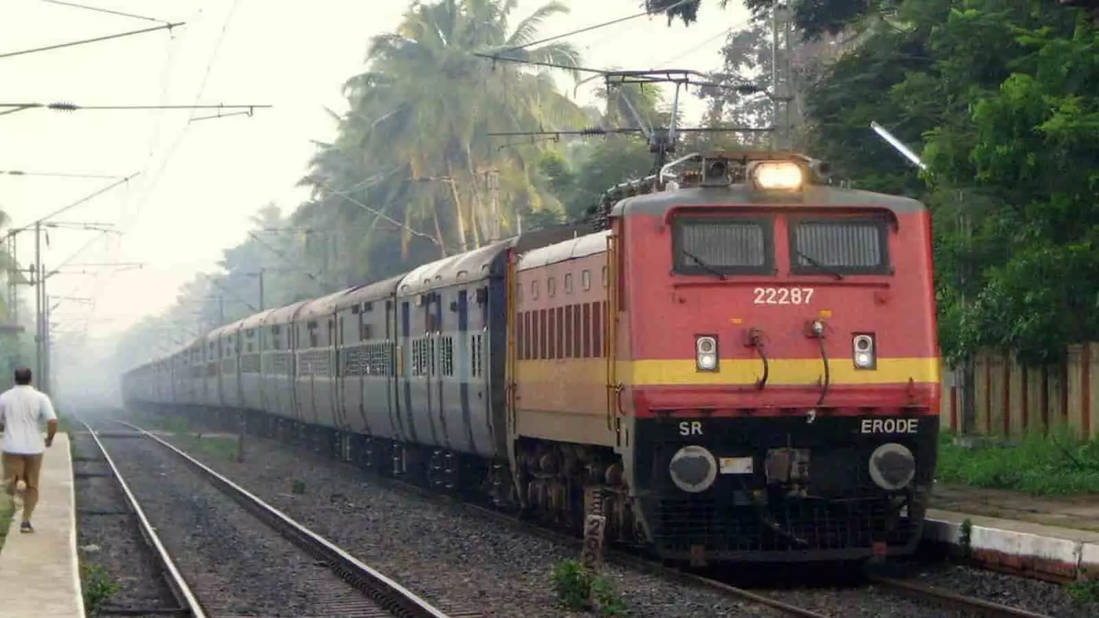 तस्वीर में रेलवे ट्रैक पर ट्रेन और प्लेटफॉर्म पर एक व्यक्ति दिख रहा है। तस्वीर में रेलवे ट्रैक पर ट्रेन और प्लेटफॉर्म पर एक व्यक्ति दिख रहा है।