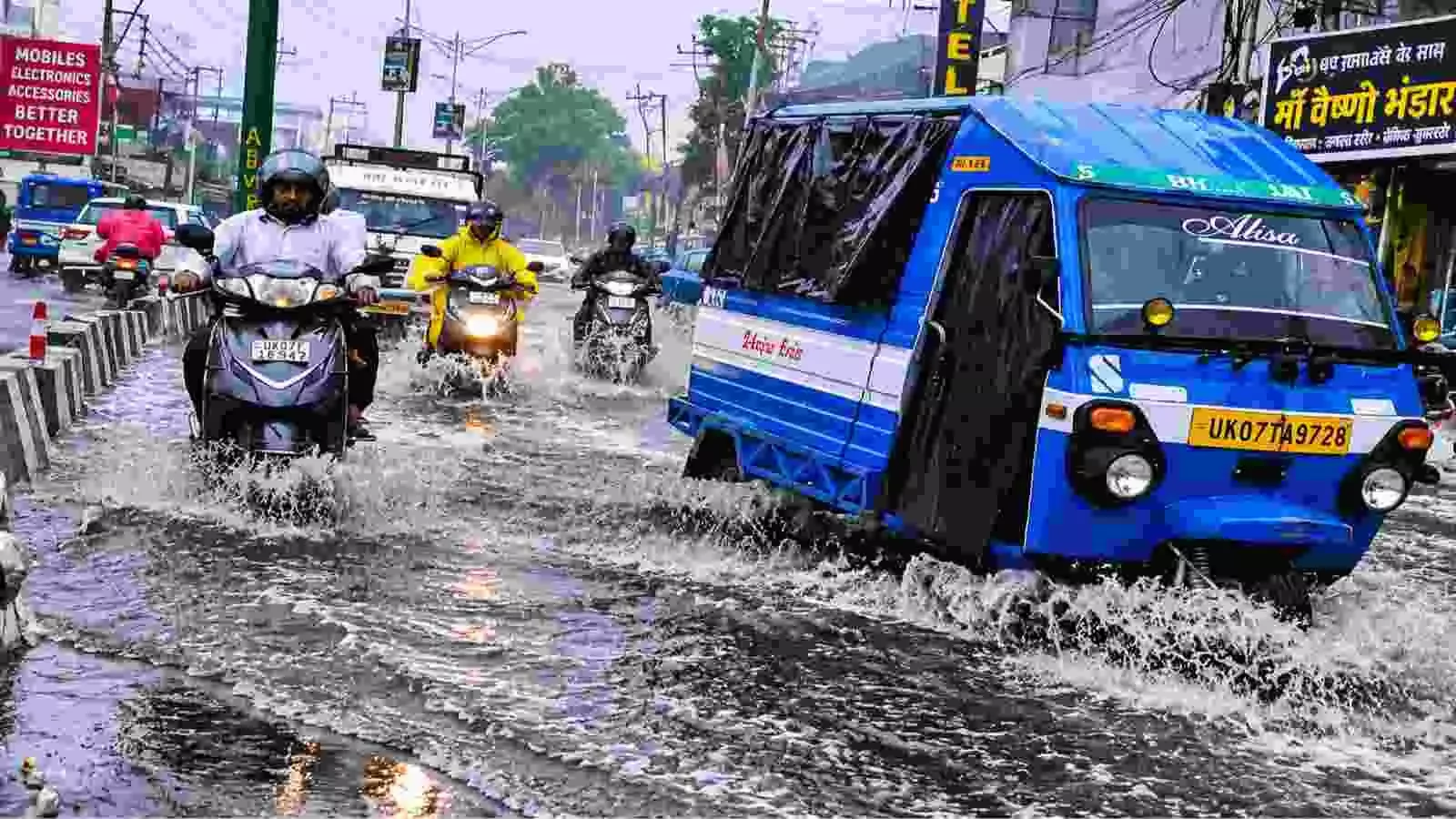 बारिश में सड़क पर वाहन चलाते लोग और ऑटो| बारिश में सड़क पर वाहन चलाते लोग और ऑटो|