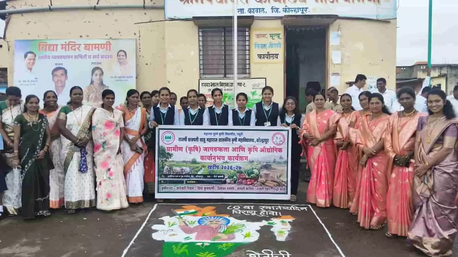 तस्वीर में बामणी गांव में ग्राम पंचायत के सामने स्वतंत्रता दिवस पर कृषिकन्याएं और ग्रामीण बैनर तथा रंगोली के साथ खड़े दिख रहे हैं। तस्वीर में बामणी गांव में ग्राम पंचायत के सामने स्वतंत्रता दिवस पर कृषिकन्याएं और ग्रामीण बैनर तथा रंगोली के साथ खड़े दिख रहे हैं।