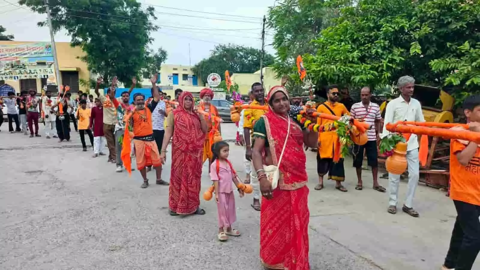 कावड़ यात्रा के दौरान सड़क पर श्रद्धालु अपने कंधों पर कावड़ रखकर चलते हुए। कावड़ यात्रा के दौरान सड़क पर श्रद्धालु अपने कंधों पर कावड़ रखकर चलते हुए।