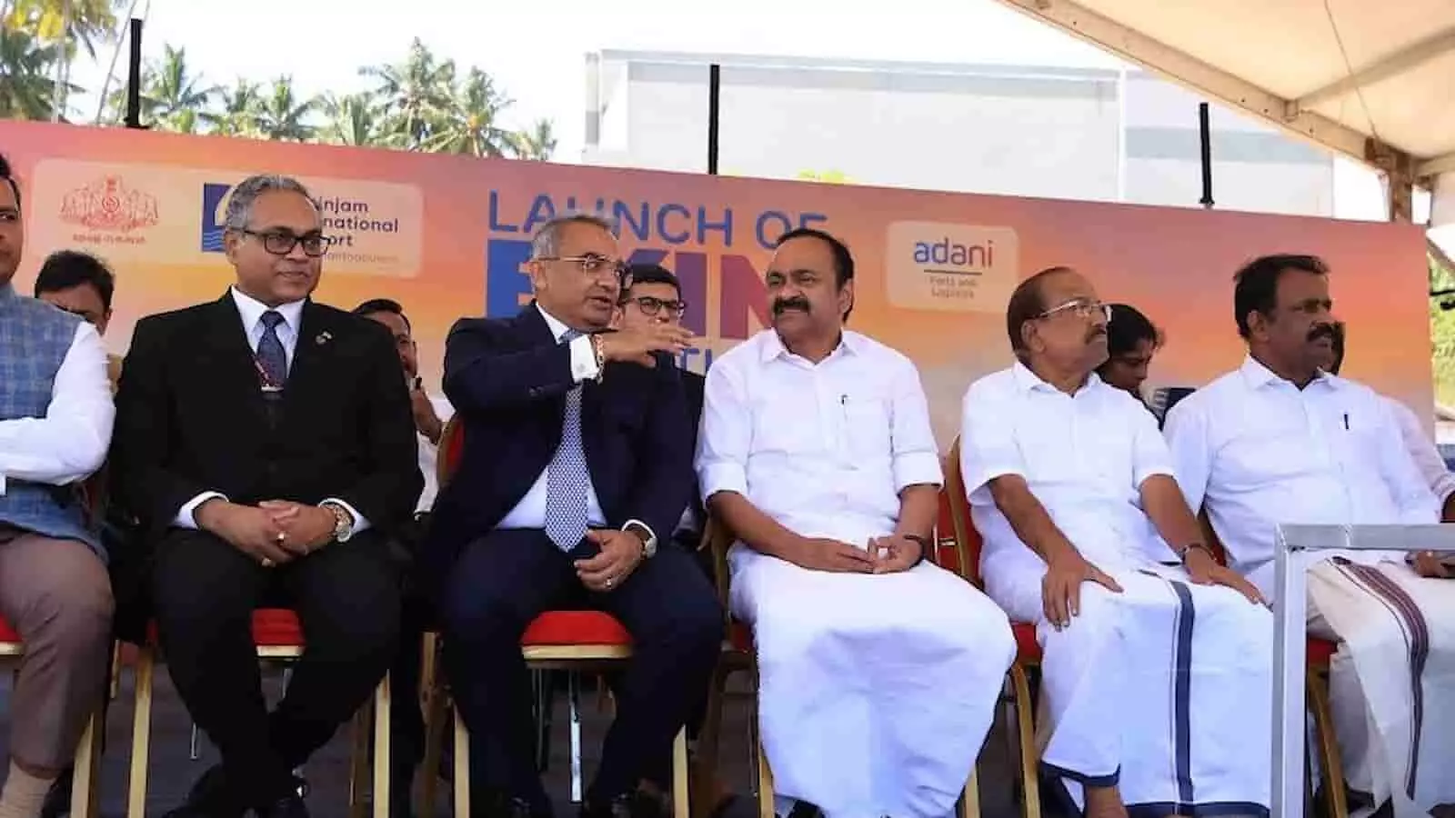 तस्वीर में विझिंजम इंटरनेशनल सीपोर्ट पर EXIM ऑपरेशन के उद्घाटन कार्यक्रम के दौरान मंच पर बैठे गणमान्य व्यक्ति नजर आ रहे हैं। तस्वीर में विझिंजम इंटरनेशनल सीपोर्ट पर EXIM ऑपरेशन के उद्घाटन कार्यक्रम के दौरान मंच पर बैठे गणमान्य व्यक्ति नजर आ रहे हैं।