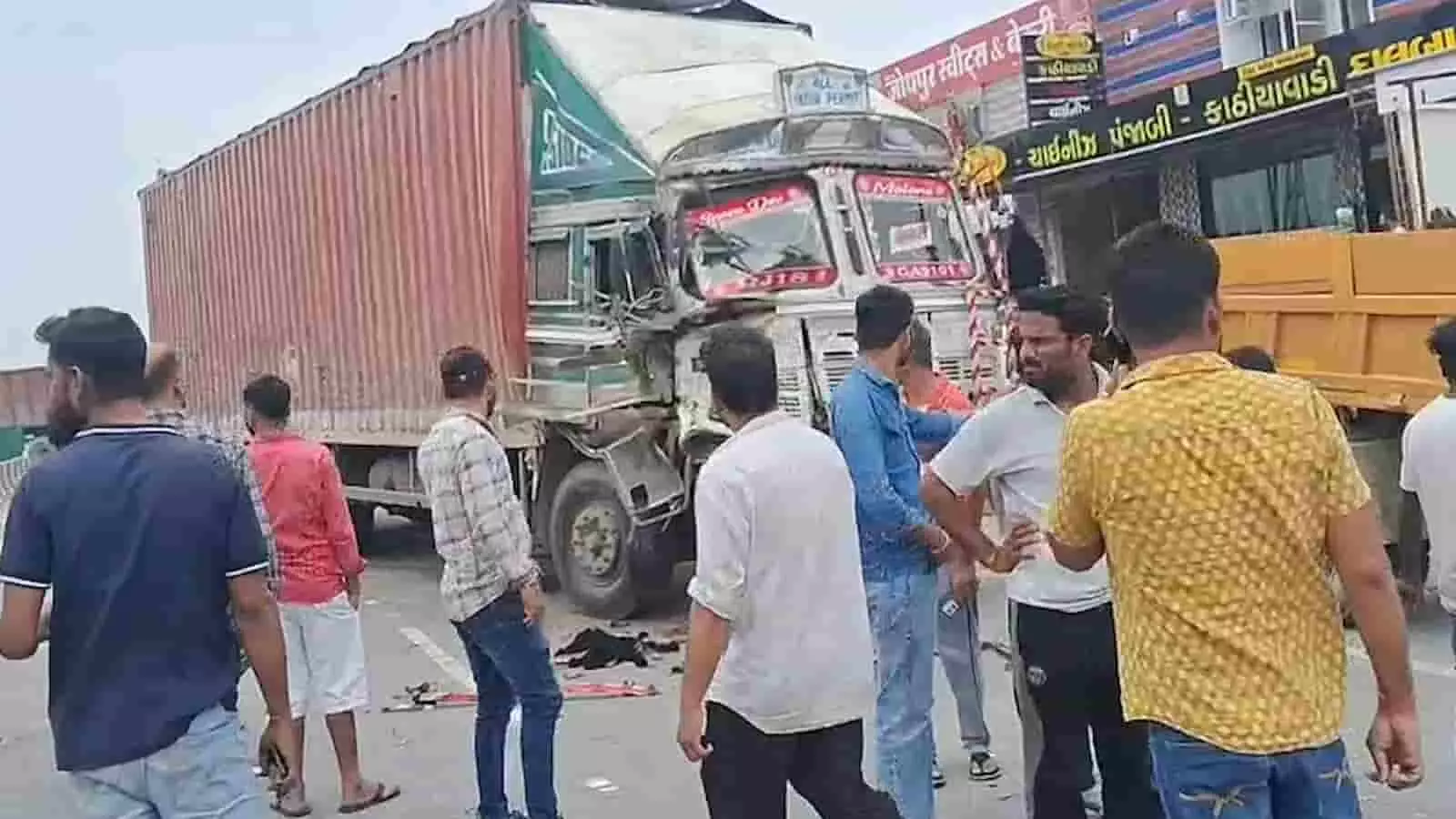 हाईवे पर दुर्घटनाग्रस्त ट्रक के पास खड़े लोगों की भीड़ दिखाई दे रही है। हाईवे पर दुर्घटनाग्रस्त ट्रक के पास खड़े लोगों की भीड़ दिखाई दे रही है।