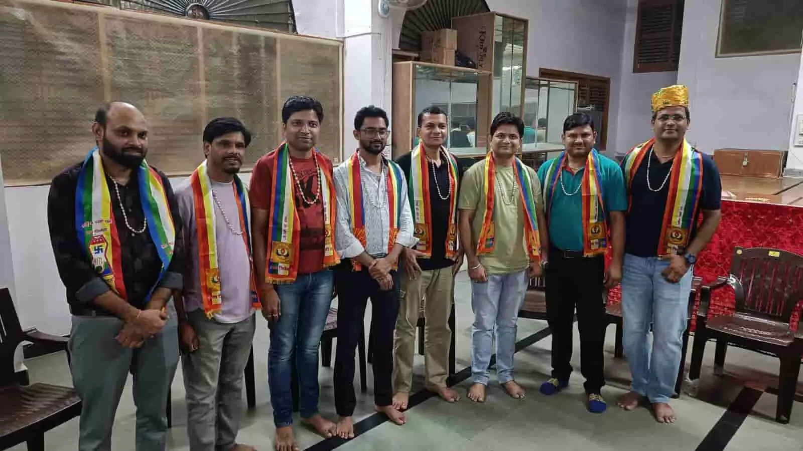 खेरवाड़ा में आठ पुरुष रंगीन पट्टे पहनकर एक साथ खड़े हैं। खेरवाड़ा में आठ पुरुष रंगीन पट्टे पहनकर एक साथ खड़े हैं।