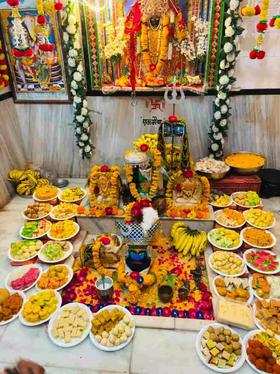 तस्वीर में मंदिर में शिवलिंग, प्रतिमाएं और छप्पन भोग की थालियां दिख रही हैं। तस्वीर में मंदिर में शिवलिंग, प्रतिमाएं और छप्पन भोग की थालियां दिख रही हैं।