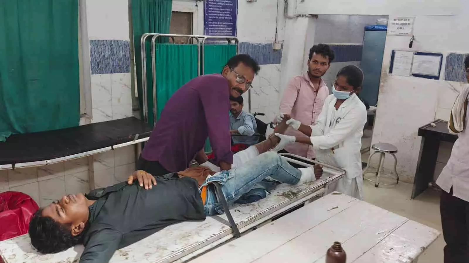 अस्पताल के कमरे में घायल मरीज का उपचार करते डॉक्टर और मेडिकल स्टाफ। अस्पताल के कमरे में घायल मरीज का उपचार करते डॉक्टर और मेडिकल स्टाफ।