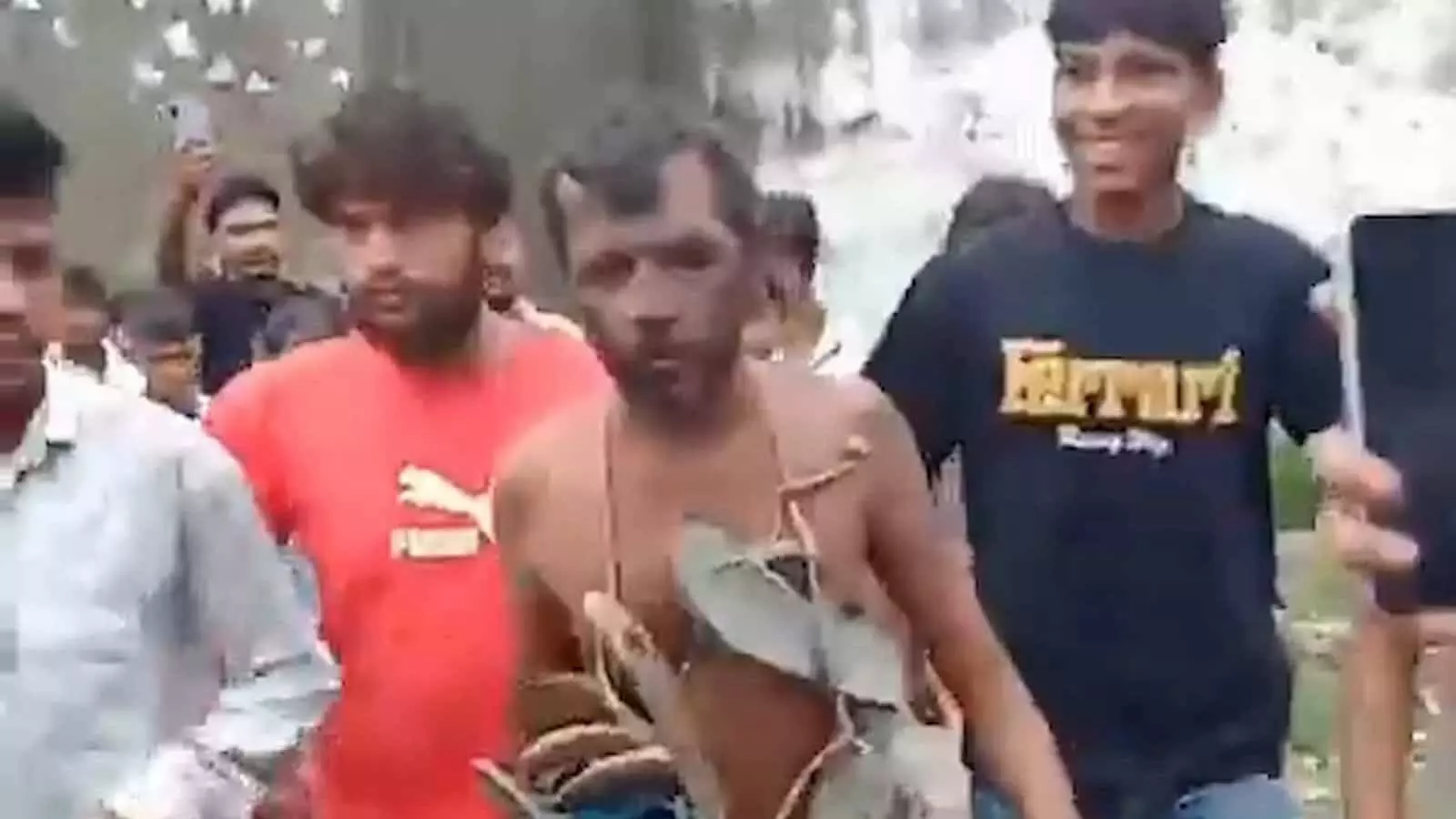 तस्वीर में भीड़ के बीच एक व्यक्ति को चप्पलों की माला पहनाकर घुमाया जा रहा है। तस्वीर में भीड़ के बीच एक व्यक्ति को चप्पलों की माला पहनाकर घुमाया जा रहा है।