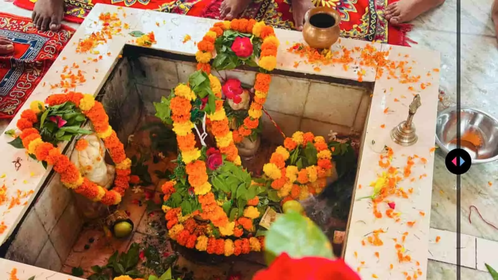 भक्तों द्वारा मंदिर में फूलों से सजे शिवलिंग की पूजा-अर्चना का दृश्य। भक्तों द्वारा मंदिर में फूलों से सजे शिवलिंग की पूजा-अर्चना का दृश्य।