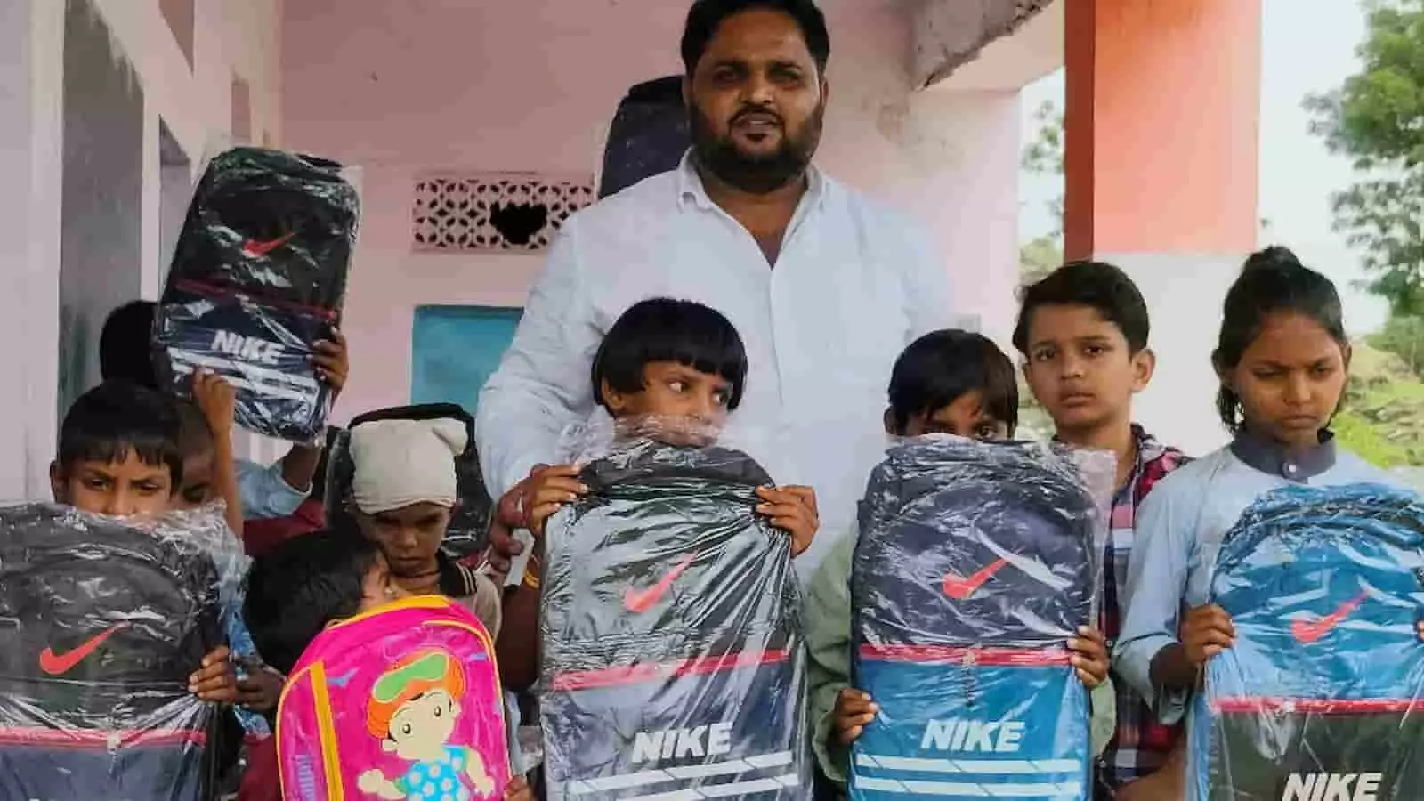 तस्वीर में खेरवाड़ा के विद्यालय में छात्रों को स्कूल बैग दिखाते हुए लोग नजर आ रहे हैं। तस्वीर में खेरवाड़ा के विद्यालय में छात्रों को स्कूल बैग दिखाते हुए लोग नजर आ रहे हैं।