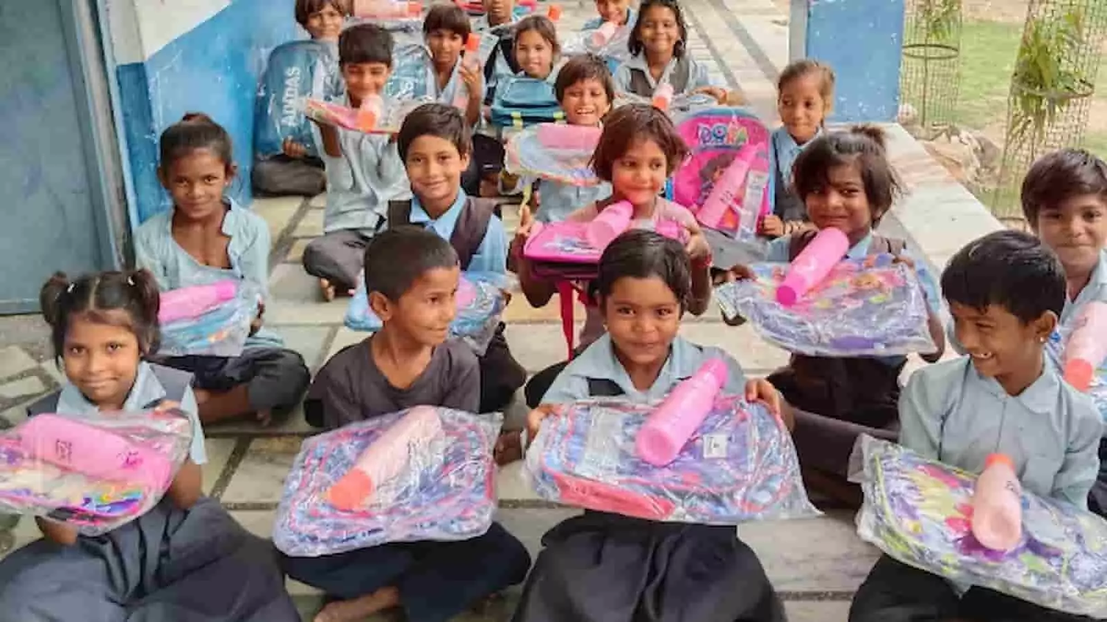 तस्वीर में वनवेरिया विद्यालय के छात्र हाथ में स्कूल बैग और बोतलें पकड़े बैठे हैं। तस्वीर में वनवेरिया विद्यालय के छात्र हाथ में स्कूल बैग और बोतलें पकड़े बैठे हैं।