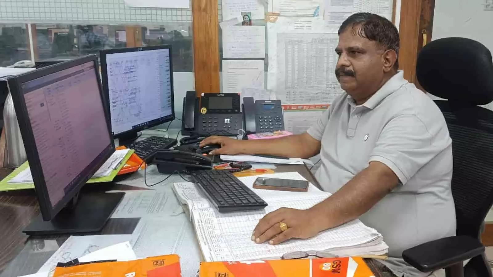 कार्यालय में डेस्क पर बैठकर कंप्यूटर और दस्तावेजों से ट्रेनों के संचालन की निगरानी करते अधिकारी। कार्यालय में डेस्क पर बैठकर कंप्यूटर और दस्तावेजों से ट्रेनों के संचालन की निगरानी करते अधिकारी।