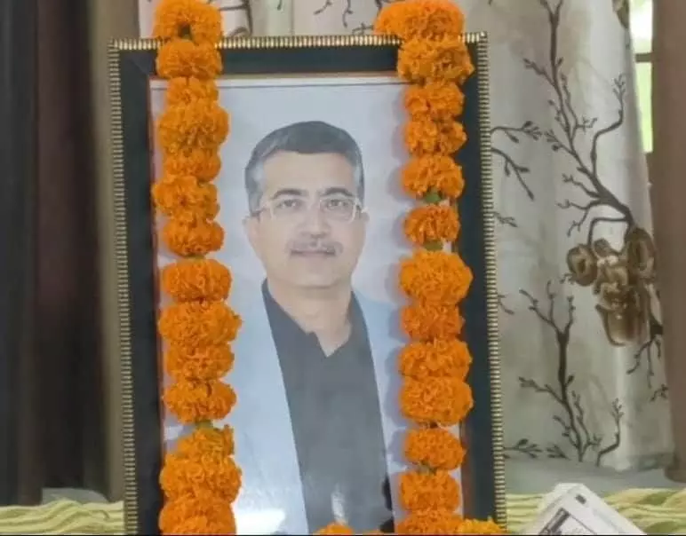 तस्वीर में गेंदे के फूलों की माला से सजी स्व. हेमेंद्र सिंह झाला की फ्रेम की गई तस्वीर दिख रही है। तस्वीर में गेंदे के फूलों की माला से सजी स्व. हेमेंद्र सिंह झाला की फ्रेम की गई तस्वीर दिख रही है।