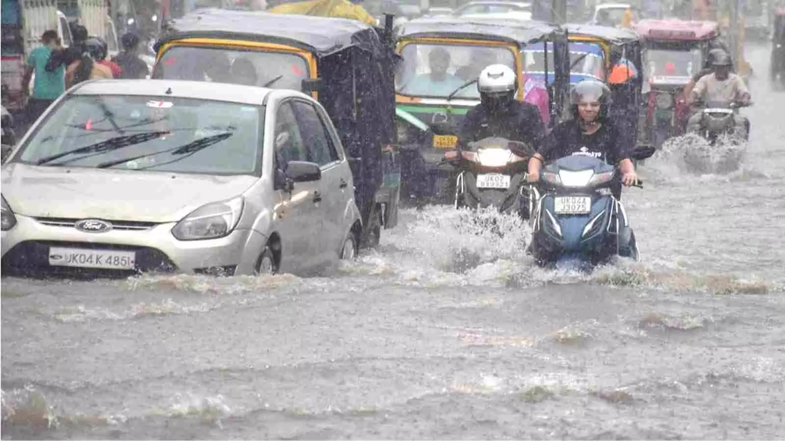 उत्तर भारत के वर्षा प्रभावित क्षेत्र में लोग पानी भरे मार्ग से वाहन निकाल रहे हैं। उत्तर भारत के वर्षा प्रभावित क्षेत्र में लोग पानी भरे मार्ग से वाहन निकाल रहे हैं।