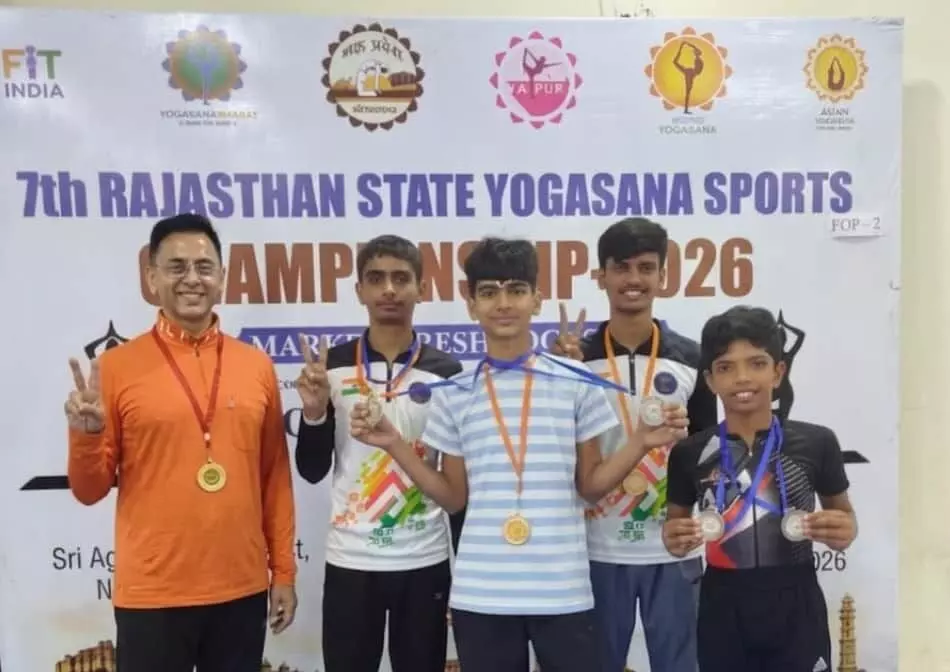 तस्वीर में 7वीं राज्य स्तरीय योगासन प्रतियोगिता के बैनर के आगे मेडल पहने खड़े उदयपुर के खिलाड़ी दिख रहे हैं। तस्वीर में 7वीं राज्य स्तरीय योगासन प्रतियोगिता के बैनर के आगे मेडल पहने खड़े उदयपुर के खिलाड़ी दिख रहे हैं।