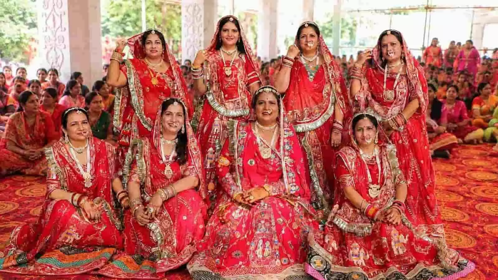 पारंपरिक लाल पोषाक में सजी महिलाएं दादी धाम उत्सव में समूह के साथ बैठी हैं। पारंपरिक लाल पोषाक में सजी महिलाएं दादी धाम उत्सव में समूह के साथ बैठी हैं।