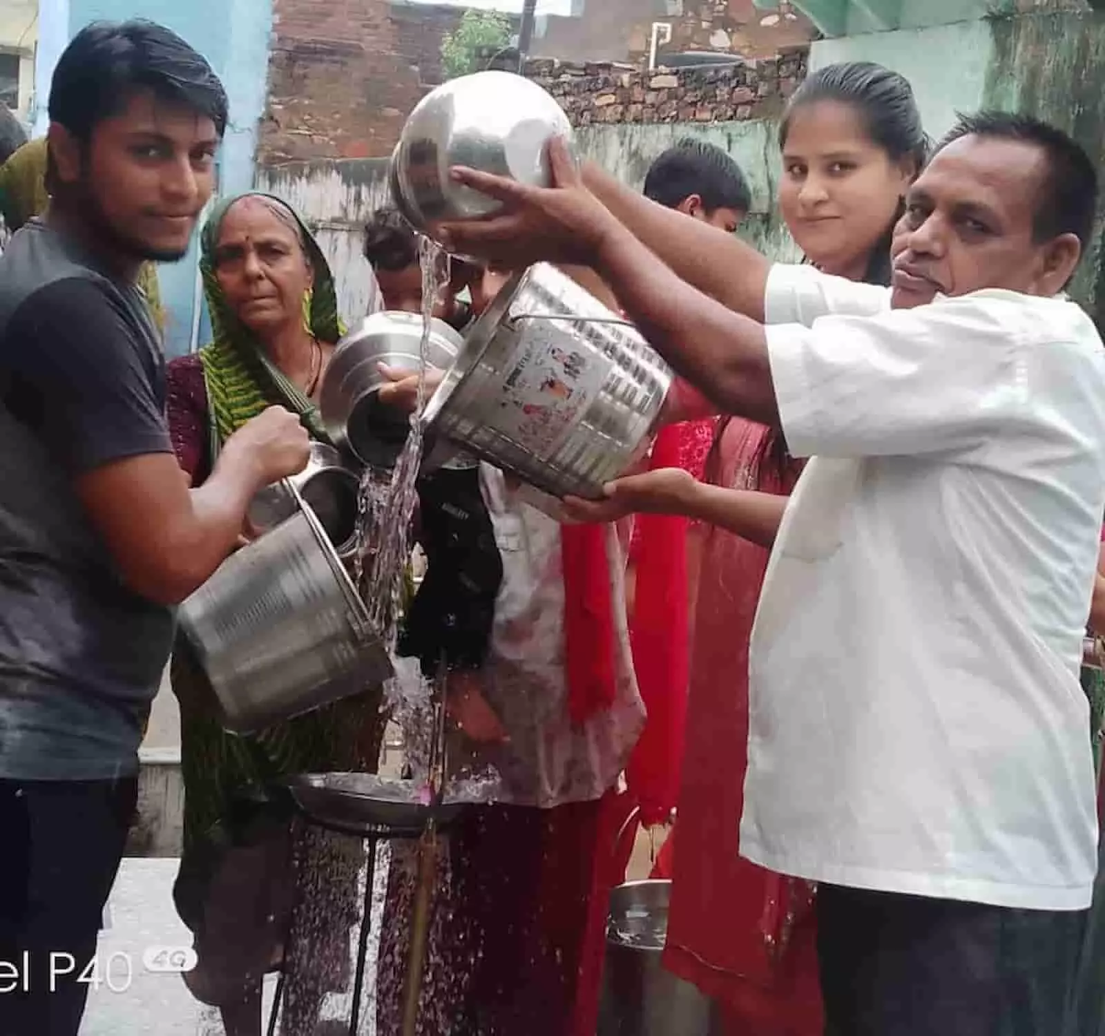तस्वीर में शिव भक्त मंदिर परिसर में खड़े होकर जल चढ़ाते हुए दिखाई दे रहे हैं। तस्वीर में शिव भक्त मंदिर परिसर में खड़े होकर जल चढ़ाते हुए दिखाई दे रहे हैं।
