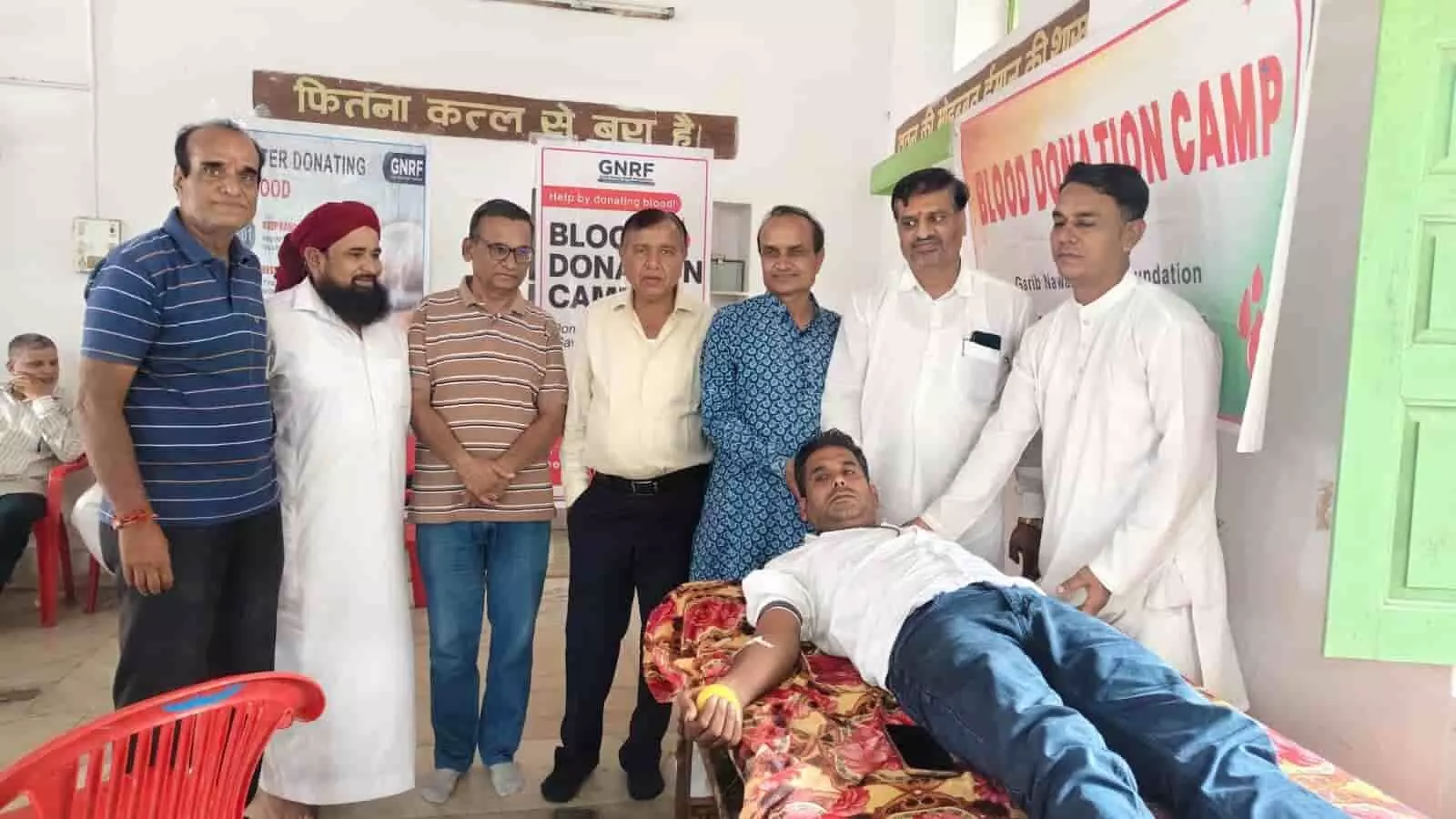 कपासन में रक्तदान शिविर के दौरान बेड पर लेटे व्यक्ति और खड़े लोग। कपासन में रक्तदान शिविर के दौरान बेड पर लेटे व्यक्ति और खड़े लोग।
