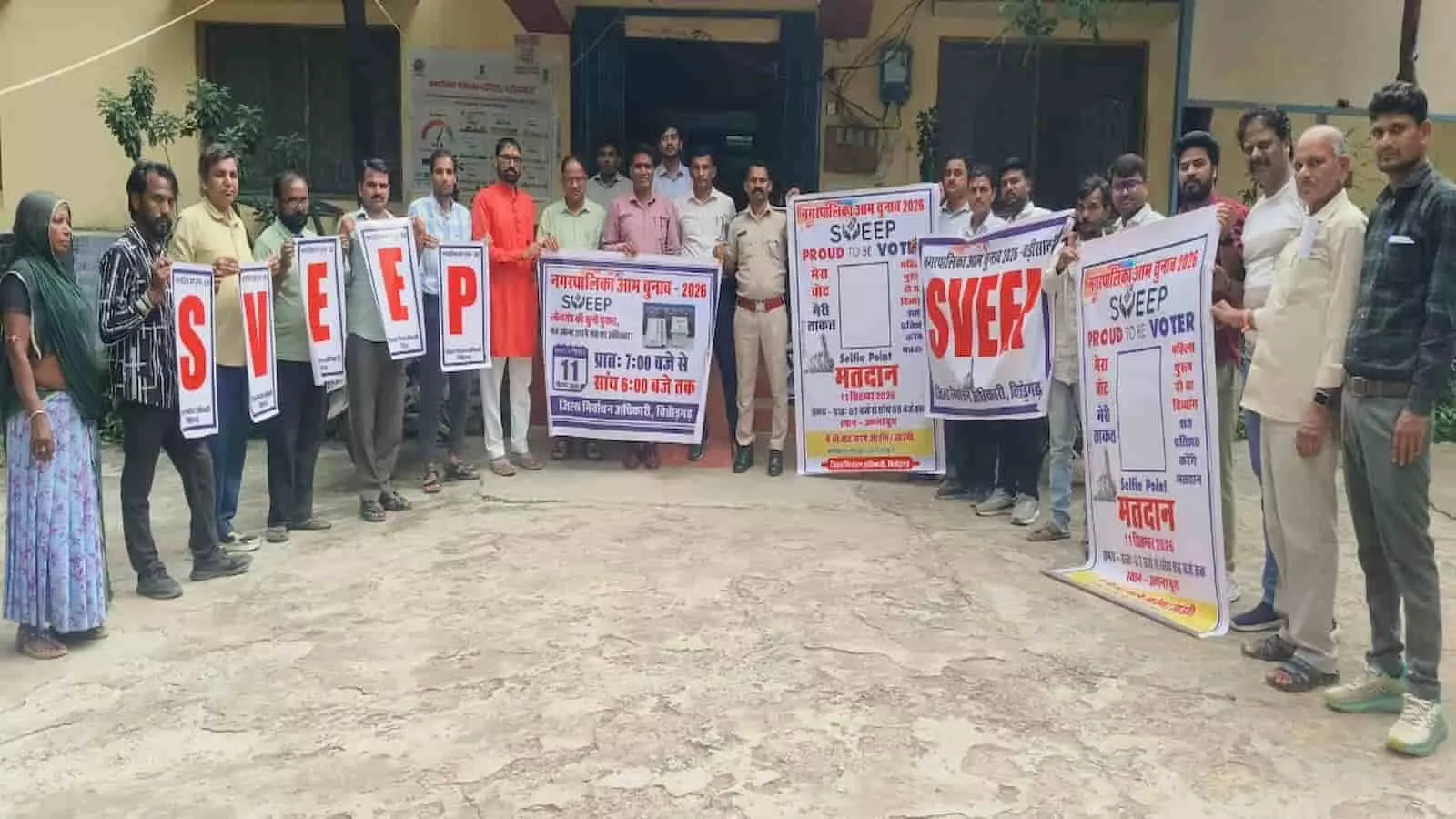 तस्वीर में अधिकारी और लोग बड़ी सादड़ी में नगर पालिका चुनाव के लिए मतदाता जागरूकता पोस्टर पकड़े खड़े हैं। तस्वीर में अधिकारी और लोग बड़ी सादड़ी में नगर पालिका चुनाव के लिए मतदाता जागरूकता पोस्टर पकड़े खड़े हैं।