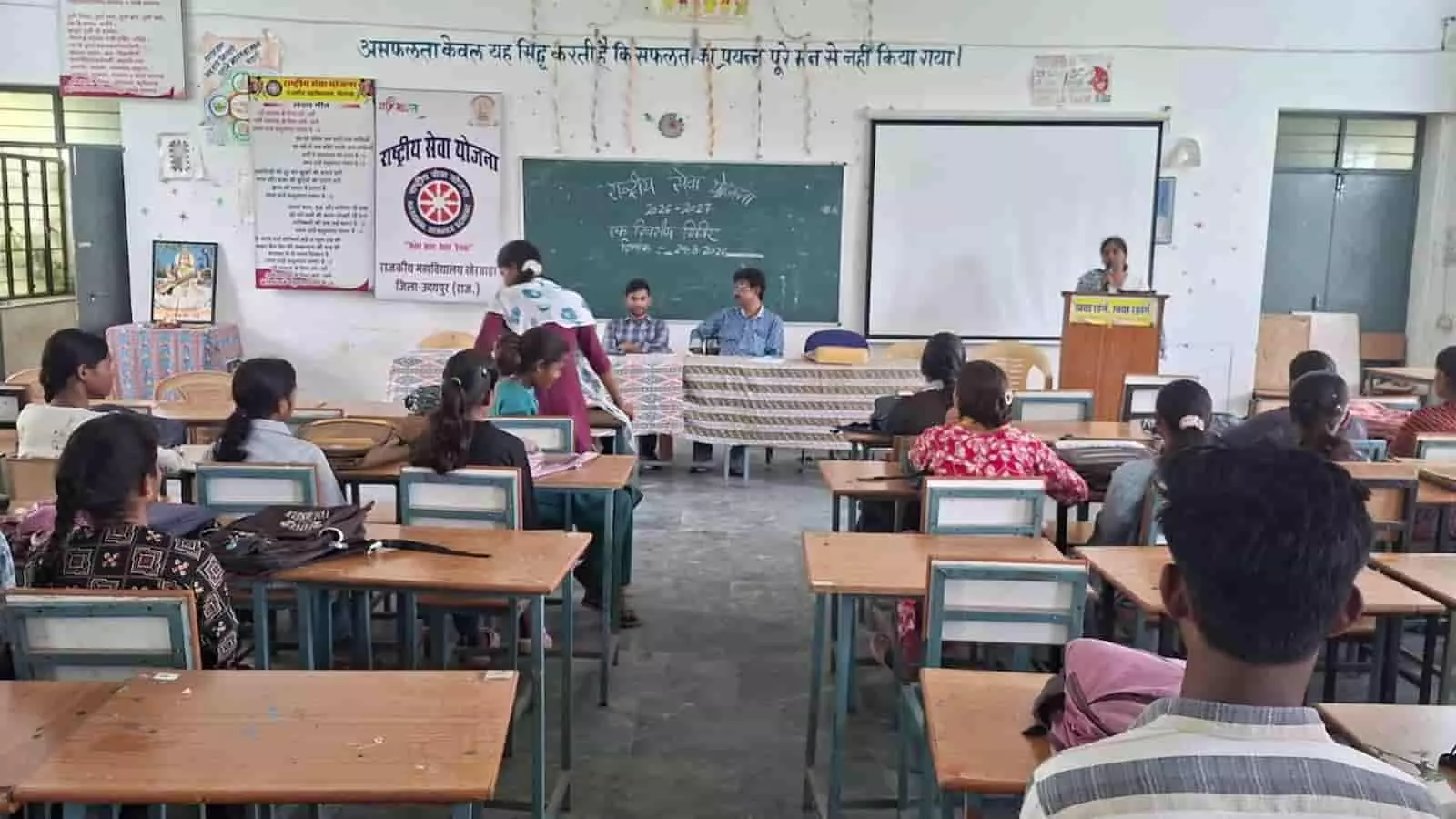 राजकीय महाविद्यालय खैरवाड़ा में एनएसएस आमुखीकरण कार्यशाला के दौरान मंच पर बोलते हुए प्राचार्या और सामने बैठे स्वयंसेवक। राजकीय महाविद्यालय खैरवाड़ा में एनएसएस आमुखीकरण कार्यशाला के दौरान मंच पर बोलते हुए प्राचार्या और सामने बैठे स्वयंसेवक।