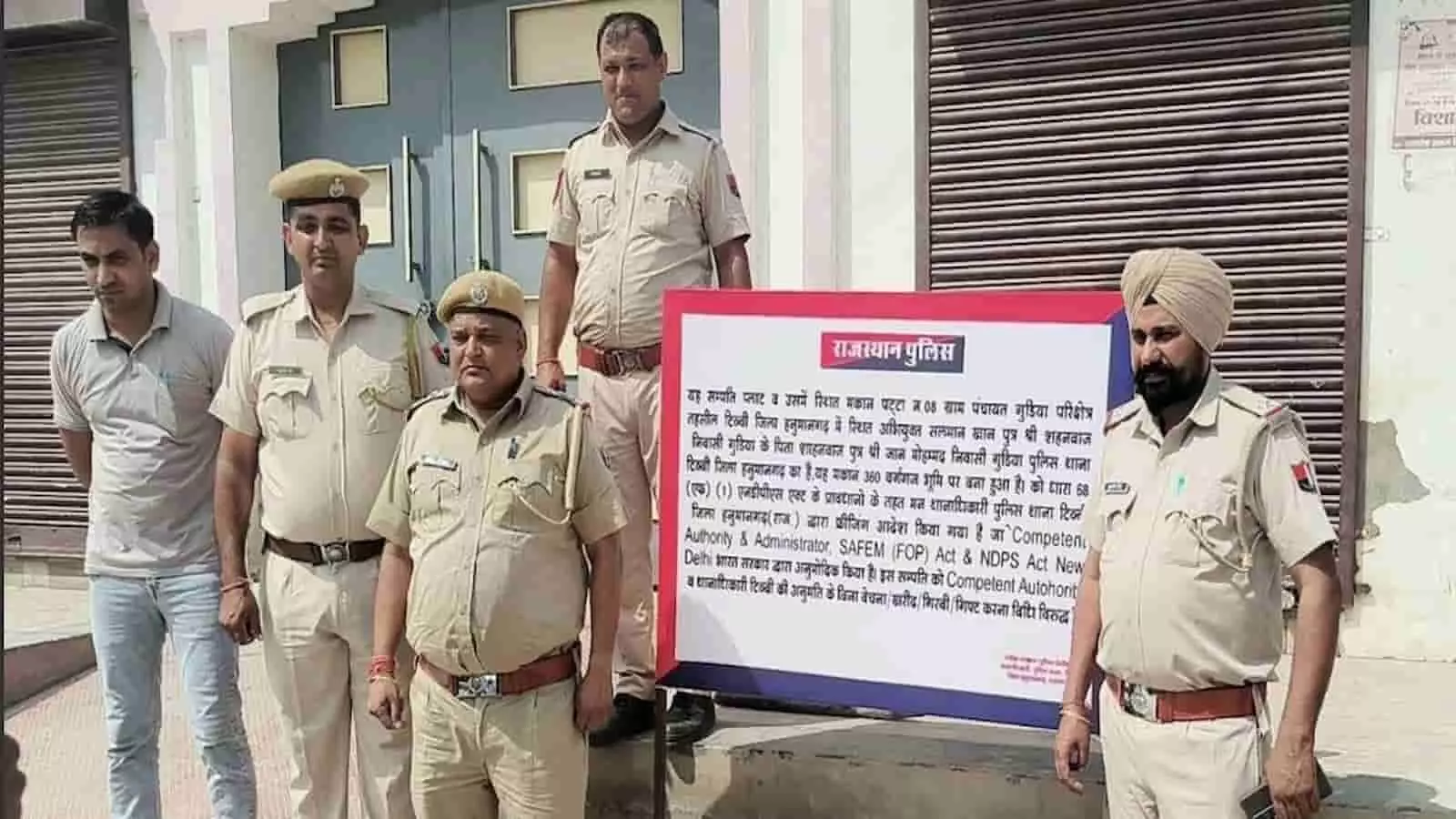 पुलिसकर्मी हनुमानगढ़ में नशा तस्कर सलमान खान के फ्रीज किए गए मकान के बाहर खड़े हैं। पुलिसकर्मी हनुमानगढ़ में नशा तस्कर सलमान खान के फ्रीज किए गए मकान के बाहर खड़े हैं।