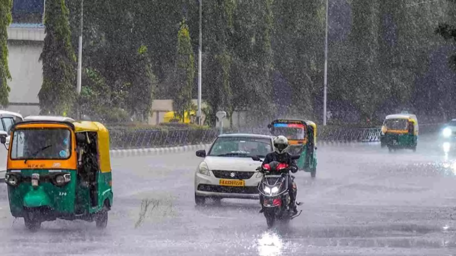 बारिश के बीच सड़क पर वाहन चलाते हुए लोग दक्षिण भारत के केरल और कर्नाटक में मौसम के संदर्भ में। बारिश के बीच सड़क पर वाहन चलाते हुए लोग दक्षिण भारत के केरल और कर्नाटक में मौसम के संदर्भ में।
