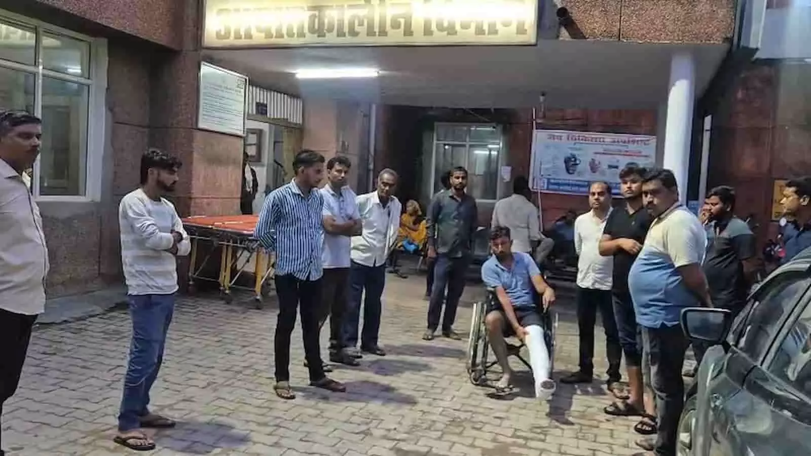 तस्वीर में एटा के अस्पताल के बाहर व्हीलचेयर पर बैठा घायल व्यक्ति और खड़े लोग दिख रहे हैं। तस्वीर में एटा के अस्पताल के बाहर व्हीलचेयर पर बैठा घायल व्यक्ति और खड़े लोग दिख रहे हैं।