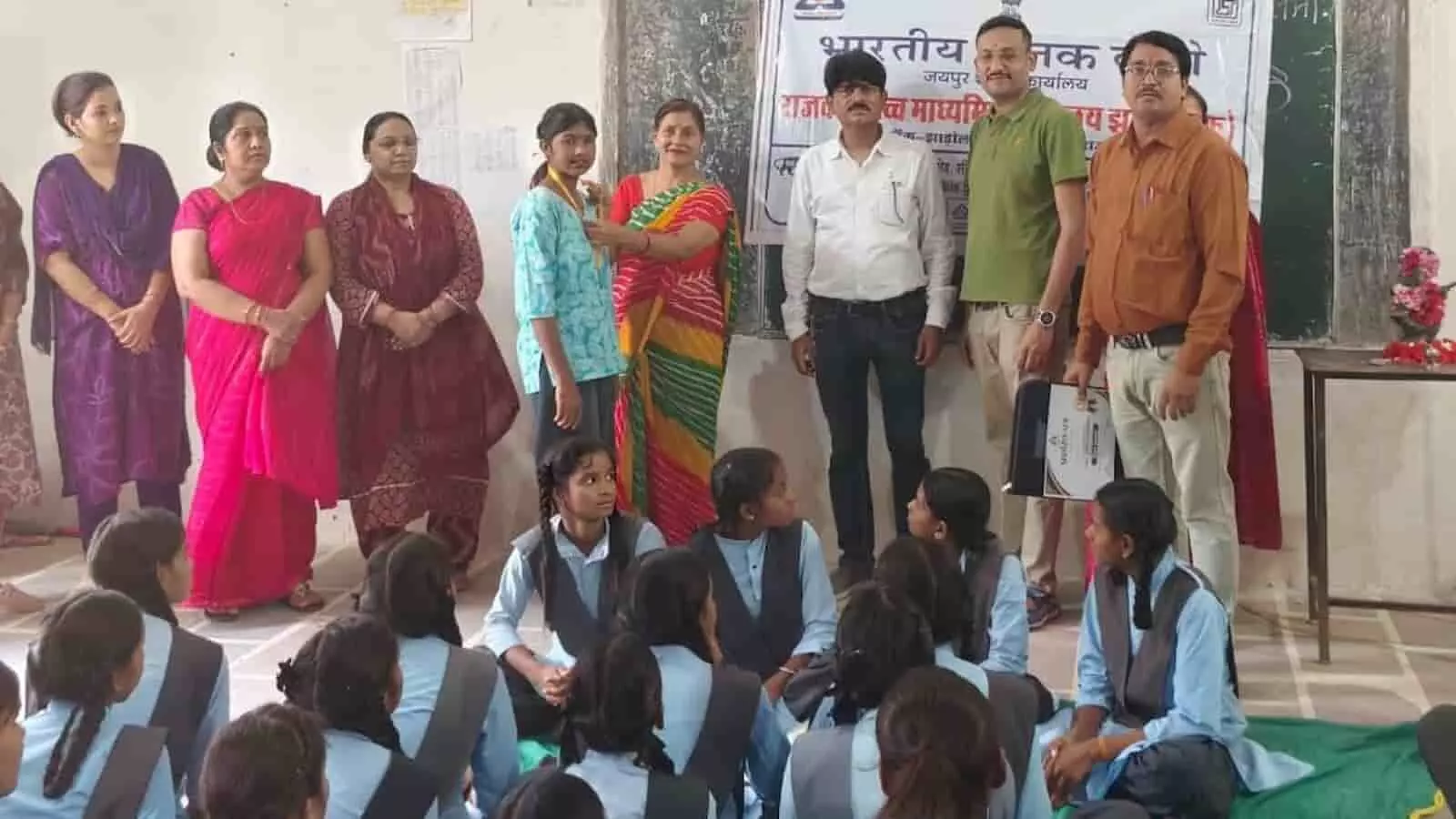 झाड़ोल स्कूल में विद्यार्थी बैठे और शिक्षक खड़े दिखाई दे रहे हैं, मानक क्लब कार्यक्रम में झाड़ोल स्कूल में विद्यार्थी बैठे और शिक्षक खड़े दिखाई दे रहे हैं, मानक क्लब कार्यक्रम में