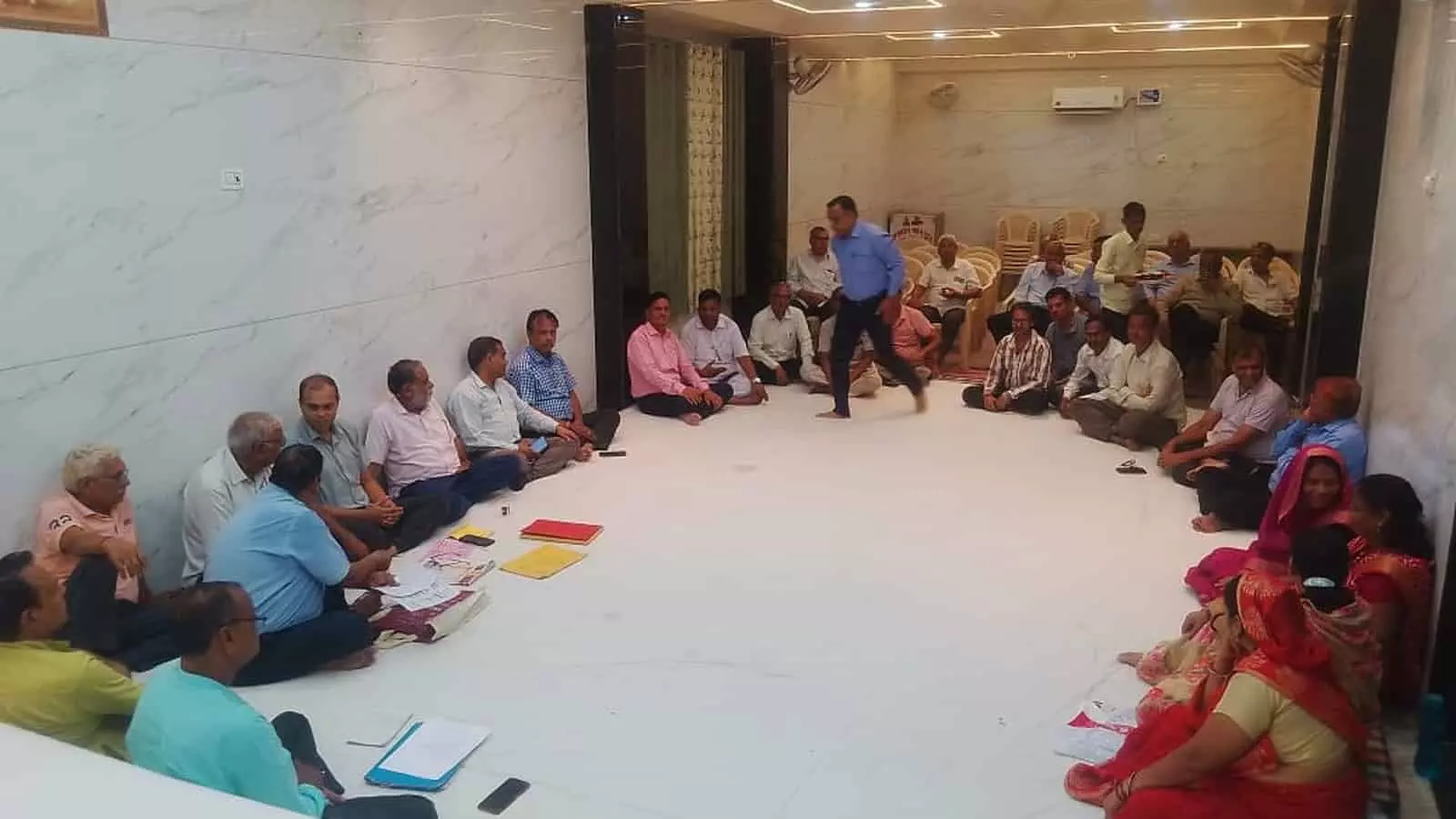 अग्रवाल भवन ट्रस्ट के हॉल में फर्श पर बैठकर बैठक करते हुए समाज के लोग और महिला सदस्य। अग्रवाल भवन ट्रस्ट के हॉल में फर्श पर बैठकर बैठक करते हुए समाज के लोग और महिला सदस्य।