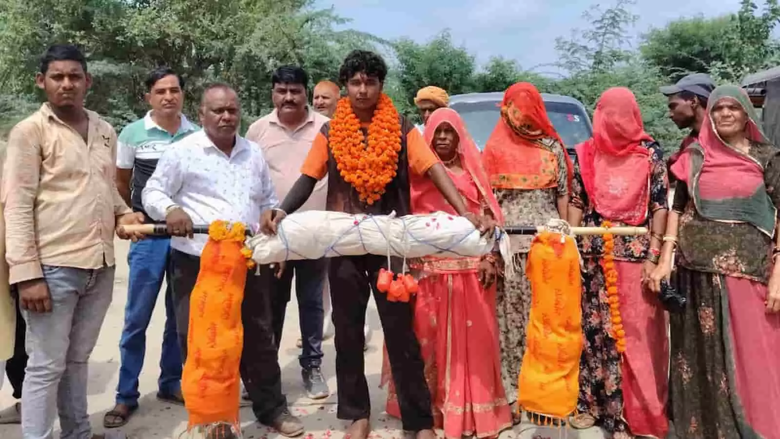 गले में फूलों की माला पहने कांवड़िए हेमेंद्र सिंह और स्वागत के लिए खड़े ग्रामीण। गले में फूलों की माला पहने कांवड़िए हेमेंद्र सिंह और स्वागत के लिए खड़े ग्रामीण।