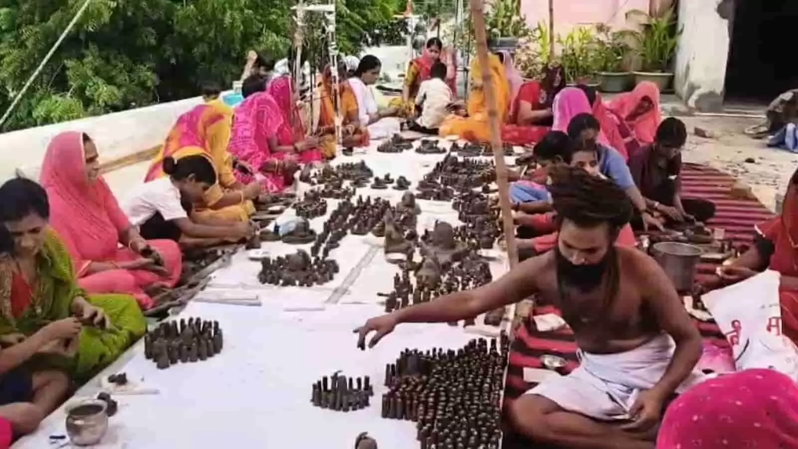 तस्वीर में आमेट के मंदिर परिसर में श्रद्धालु पार्थिव शिवलिंगों का निर्माण कर रहे हैं।