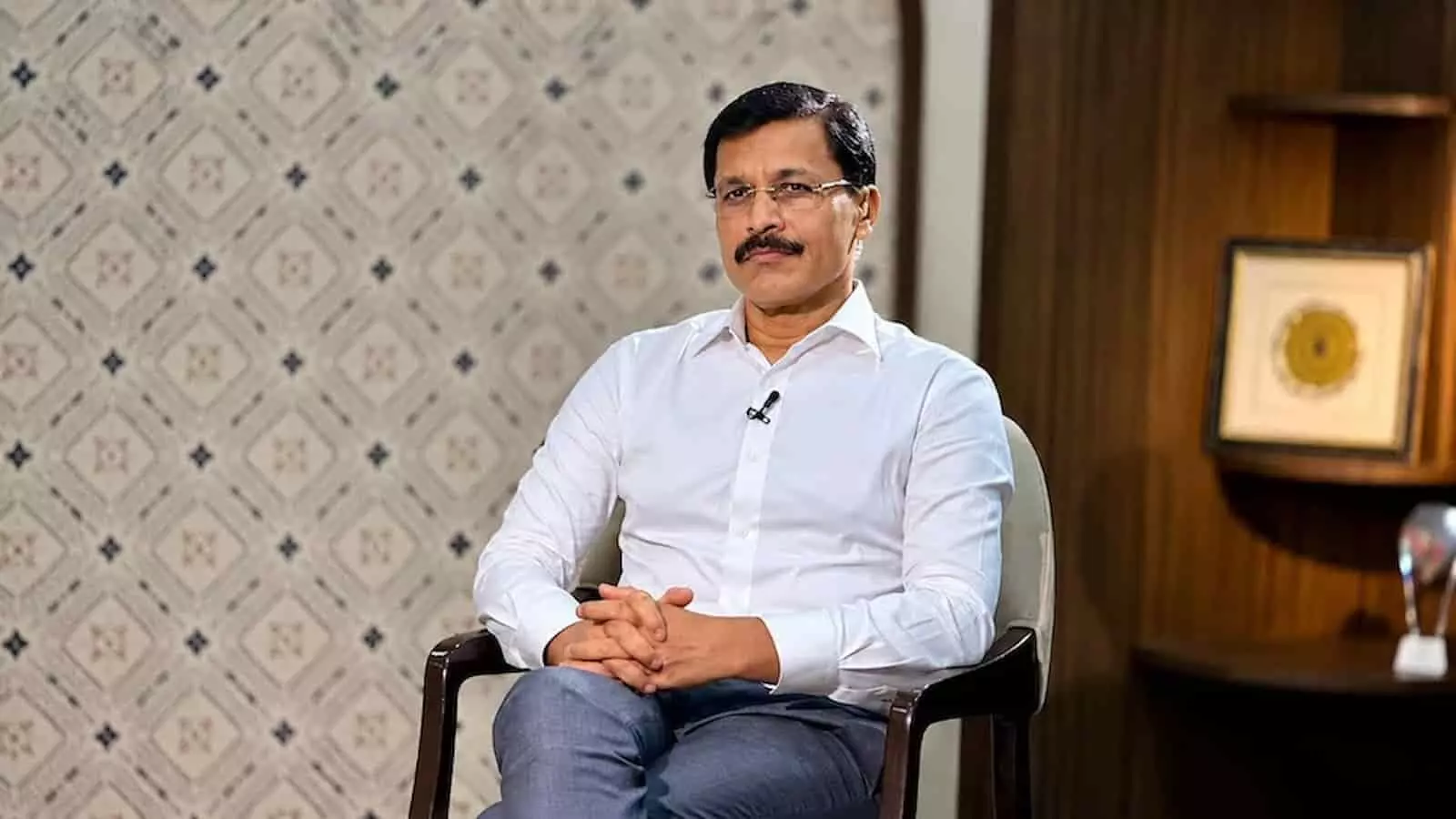 सफेद शर्ट पहने एक व्यक्ति कुर्सी पर बैठे हुए दिखाई दे रहे हैं। सफेद शर्ट पहने एक व्यक्ति कुर्सी पर बैठे हुए दिखाई दे रहे हैं।