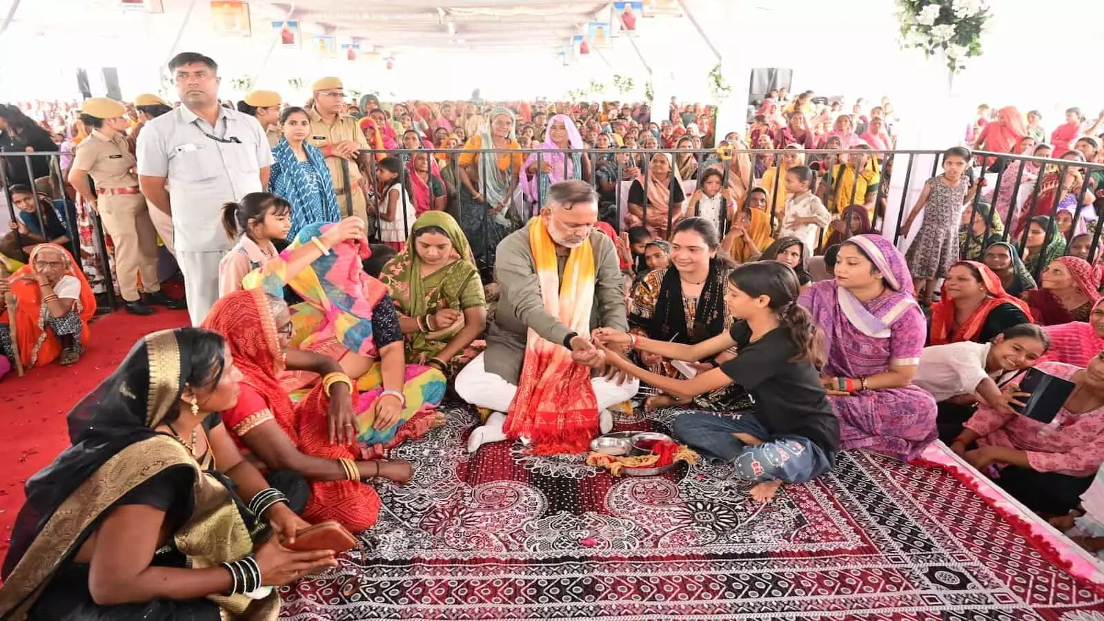 जमीन पर बैठे ऊर्जा मंत्री हीरालाल नागर को महिलाएं कनवास में रक्षासूत्र बांध रही हैं। जमीन पर बैठे ऊर्जा मंत्री हीरालाल नागर को महिलाएं कनवास में रक्षासूत्र बांध रही हैं।