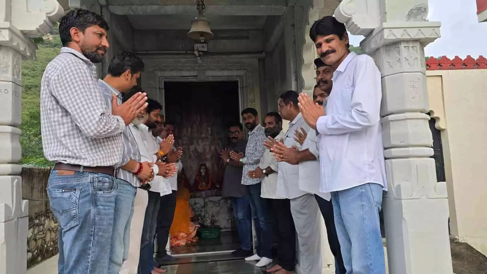 तस्वीर में पुरुष हाथ जोड़कर मंदिर के प्रवेश पर खड़े दिखाई दे रहे हैं। तस्वीर में पुरुष हाथ जोड़कर मंदिर के प्रवेश पर खड़े दिखाई दे रहे हैं।