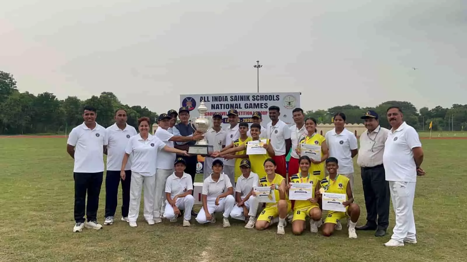 तस्वीर में कैडेट और अधिकारी एथलेटिक ग्राउंड में ट्रॉफी लेकर खड़े हैं। तस्वीर में कैडेट और अधिकारी एथलेटिक ग्राउंड में ट्रॉफी लेकर खड़े हैं।