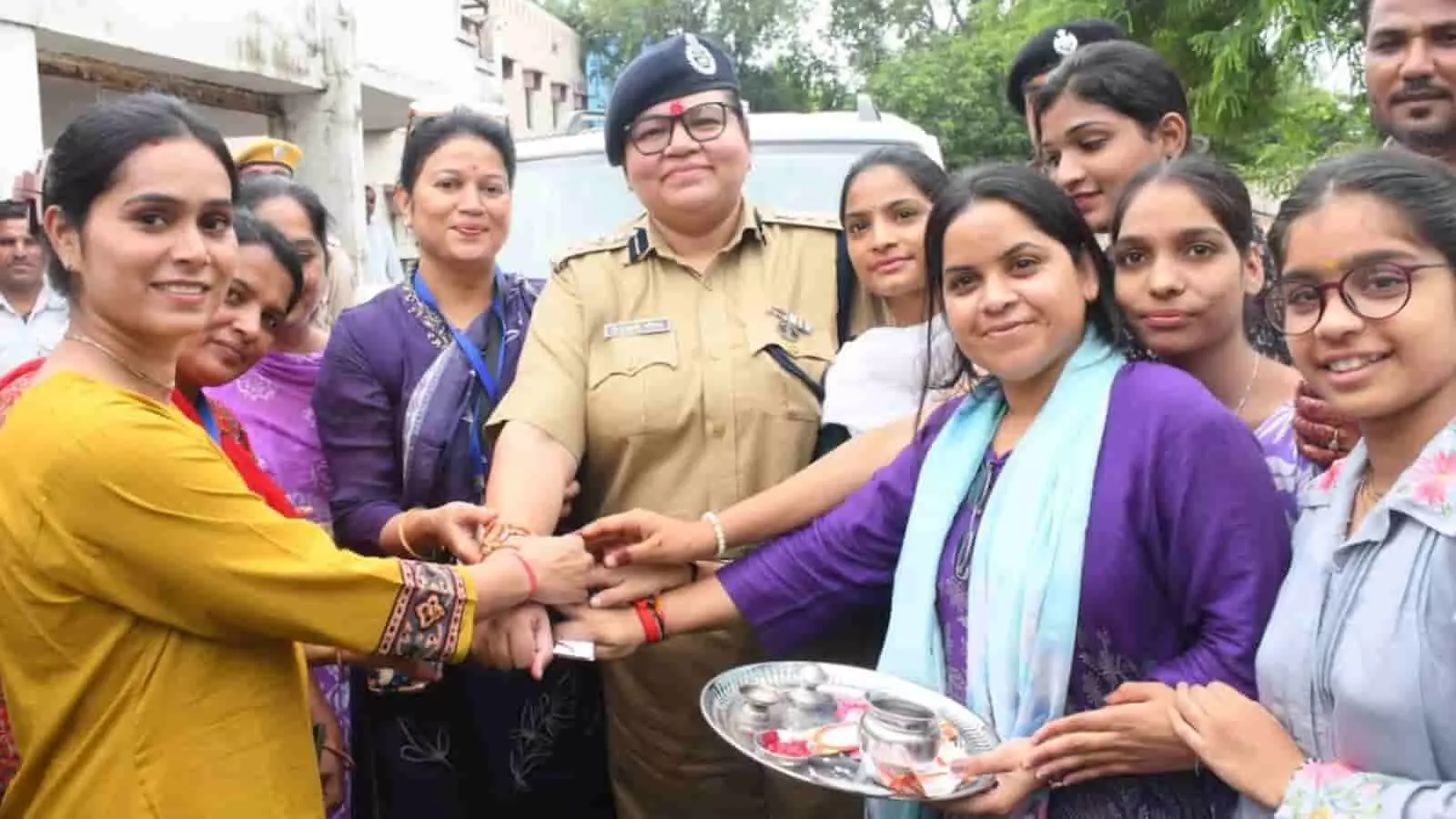 तस्वीर में महिला पुलिस अधिकारी को महिलाएं और बालिकाएं राखी बांधती हुई दिख रही हैं। तस्वीर में महिला पुलिस अधिकारी को महिलाएं और बालिकाएं राखी बांधती हुई दिख रही हैं।