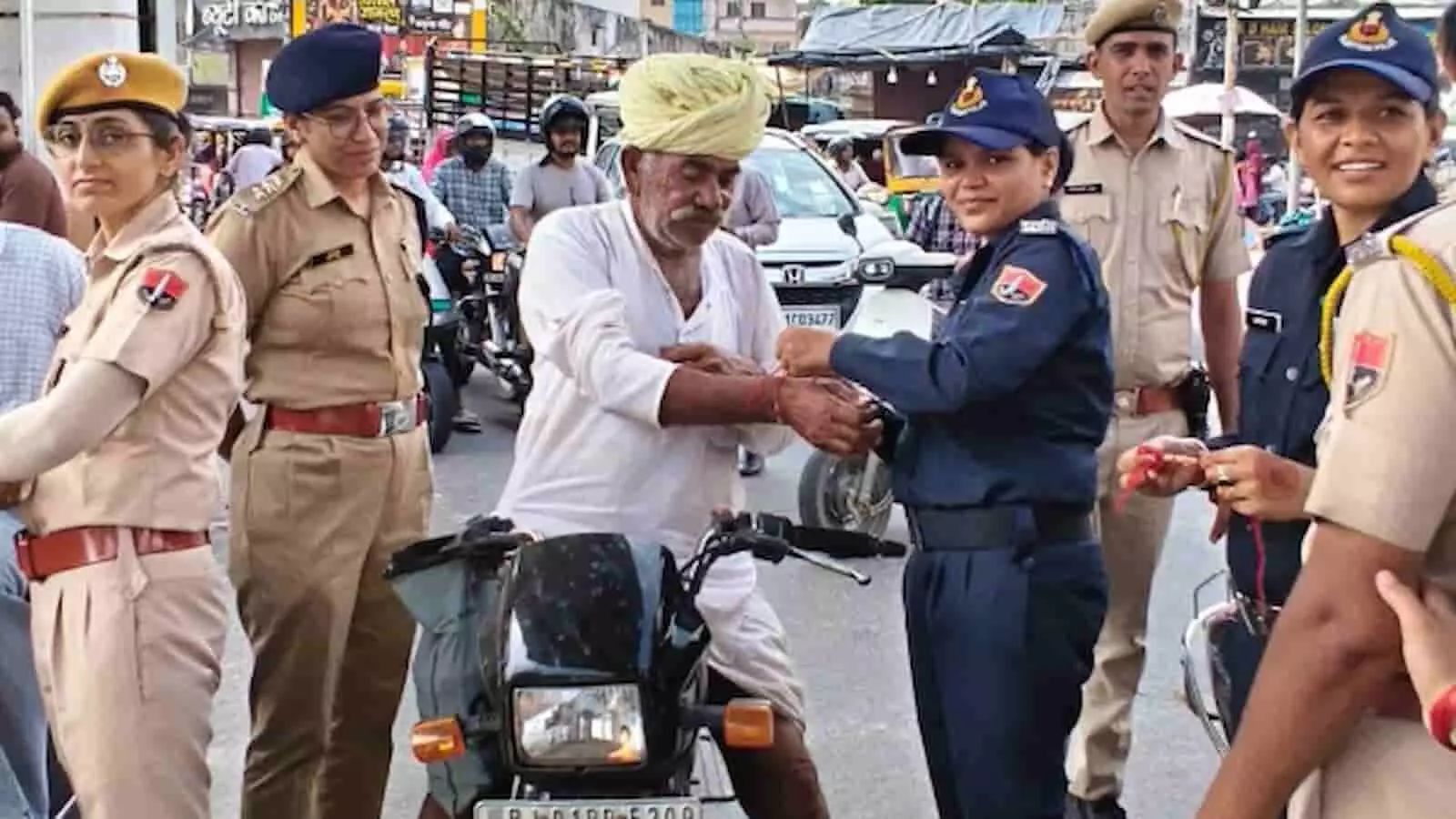 तस्वीर में पुलिसकर्मी जोधपुर की सड़क पर एक ग्रामीण व्यक्ति को राखी बांध रहे हैं। तस्वीर में पुलिसकर्मी जोधपुर की सड़क पर एक ग्रामीण व्यक्ति को राखी बांध रहे हैं।