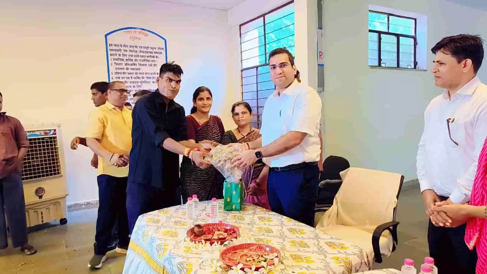 तस्वीर में अधिकारी उपहार लेते दिख रहे हैं, जामडोली गृह में राखी कार्यक्रम के दौरान तस्वीर में अधिकारी उपहार लेते दिख रहे हैं, जामडोली गृह में राखी कार्यक्रम के दौरान