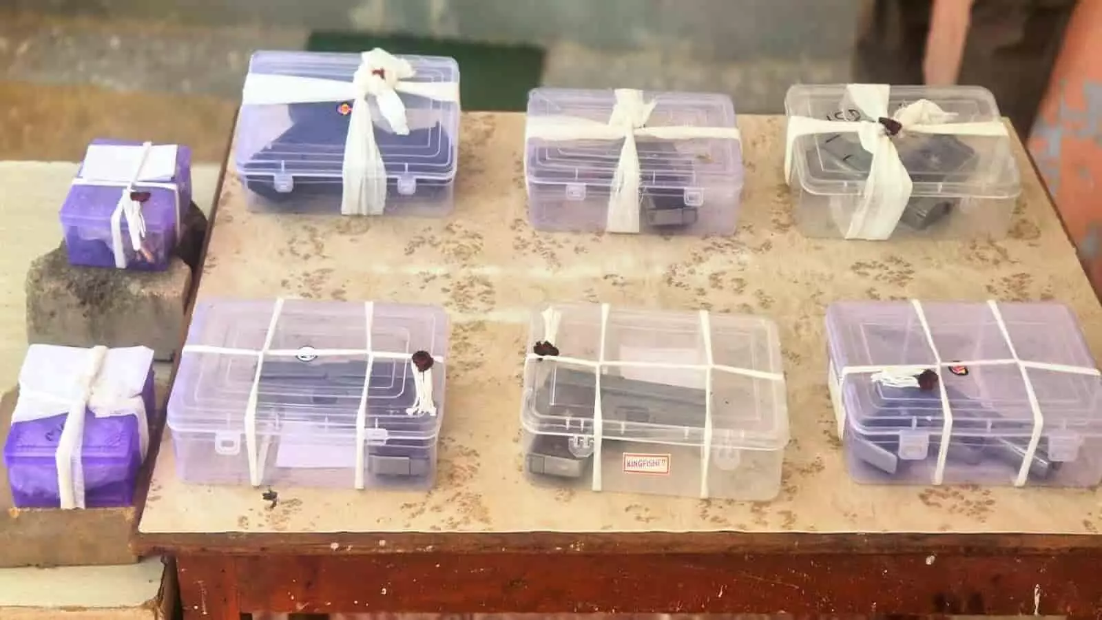 तस्वीर में मेज पर प्लास्टिक के बक्सों में रखी गई अवैध पिस्तौलें और कारतूस दिख रहे हैं। तस्वीर में मेज पर प्लास्टिक के बक्सों में रखी गई अवैध पिस्तौलें और कारतूस दिख रहे हैं।