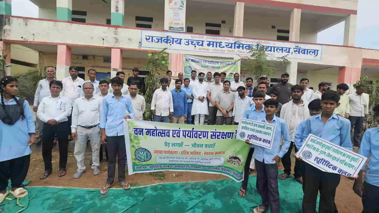 शिवाला स्कूल में वन महोत्सव के दौरान पौधे और तख्तियां लिए खड़े विद्यार्थी व ग्रामीणजन। शिवाला स्कूल में वन महोत्सव के दौरान पौधे और तख्तियां लिए खड़े विद्यार्थी व ग्रामीणजन।