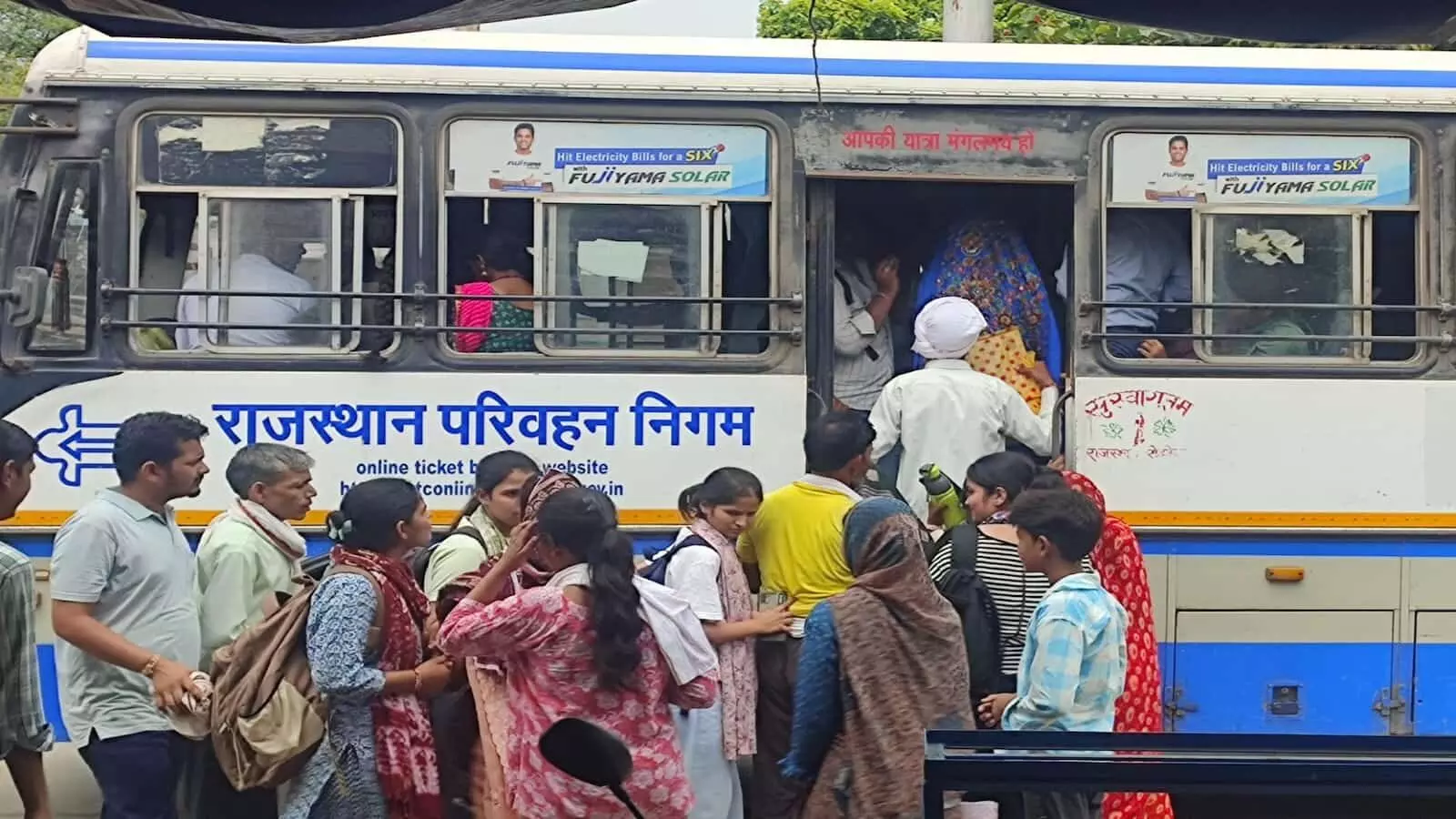 भुसावर बस स्टैंड के पास सड़क पर भीड़ के बीच तैनात पुलिसकर्मी और गुजरते वाहन भुसावर बस स्टैंड के पास सड़क पर भीड़ के बीच तैनात पुलिसकर्मी और गुजरते वाहन
