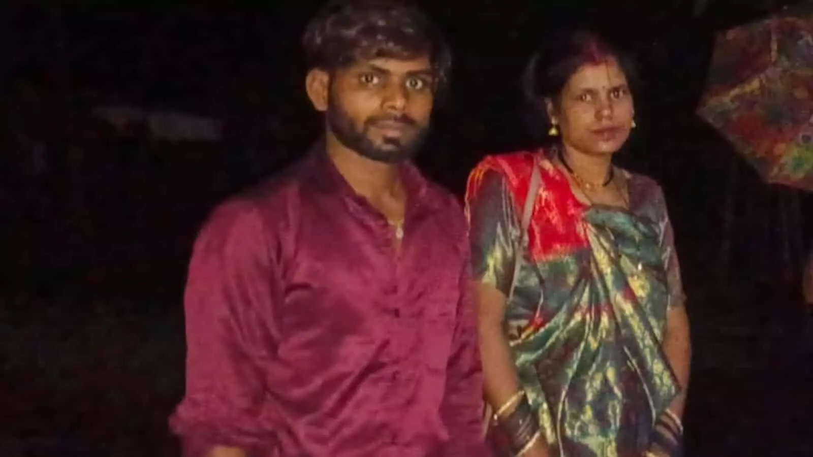 तस्वीर में रात के समय एक पुरुष और महिला खड़े हुए दिखाई दे रहे हैं। तस्वीर में रात के समय एक पुरुष और महिला खड़े हुए दिखाई दे रहे हैं।